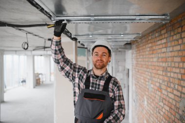 Hvac teknisyeni bir inşaat alanında havalandırma ve havalandırma sistemi kurulumu üzerinde çalışıyor.