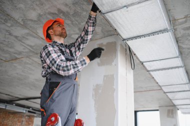 İnşaatçı inşaat sahasında çalışırken, yenileme işleri sırasında havalandırma ve havalandırma üzerine odaklanarak bir hvac sistemi kuruyor