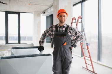 İnşaat işçisi, inşaat halindeki bir binaya havalandırma sistemi kuruyor.