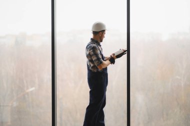 İnşaatçı yeni binada pencere kurulumu için silikon dolgu malzemesi kullanıyor, hava geçirmez ve hava geçirmez mühür sağlıyor