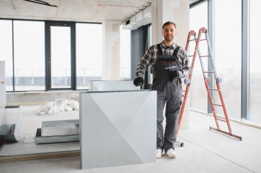 Hvac teknisyeni inşaat halindeki bir binaya havalandırma kanalı kuruyor, müstakbel kiracılar için uygun havalandırmayı sağlıyor ve kapalı hava kalitesini artırıyor.