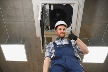 Hvac teknisyeni, bir havalandırma ünitesini başarıyla kurduktan veya onardıktan sonra, kapalı alanda rahat bir ortam sağladıktan sonra onay veriyor