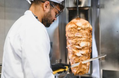 Geleneksel bir shawarma ya da kebap hazırlamak için dikey bir rostodan dilimlenmiş et dilimlemek.