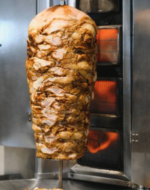 Tükürük üzerinde dönen sulu tavuk shawarma, bir sokak lokantasında yemek pişirme, servis edilmeye hazır