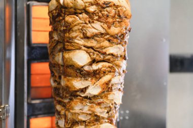 Sulu tavuk shawarma dikey ızgarada dönüyor, yavaş yavaş pişiyor ve lezzetli sokak yemekleri yapıyor.