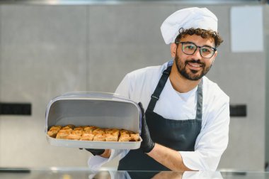 Yeni pişmiş baklava hamur işlerini sunan profesyonel şef, Orta Doğu ya da Akdeniz mutfağında uzmanlık gösteriyor