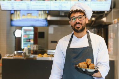 Bir ortadoğu restoranında kendine güvenen şef, doğu mutfağı ve sokak yemekleri konusunda uzmanlığını sergiliyor.