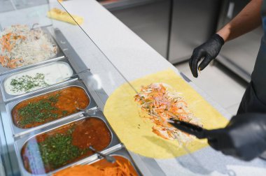 Pide ekmeğine sebze eklemek, maşa kullanmak, metal tepsilerde çeşitli malzemelerle shawarma ya da kebap hazırlamak.