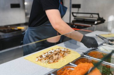 Bir fast food restoranında tavuk shawarma sosu, sokak yemeği ve doğu mutfağı konseptinde aşçı.