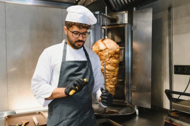 Yemek keskinleştirme bıçağı bir fast food restoranında dikey bir restorandan et kesmeye hazırlanıyor.