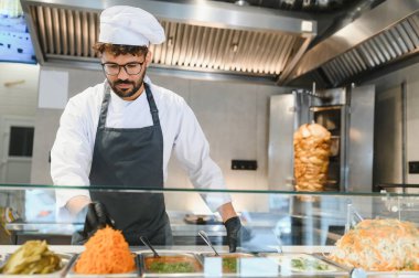 Orta Doğulu aşçı, shawarma ya da kebap gibi Arap sokak yemekleri yapmak için taze malzemeler hazırlıyor.