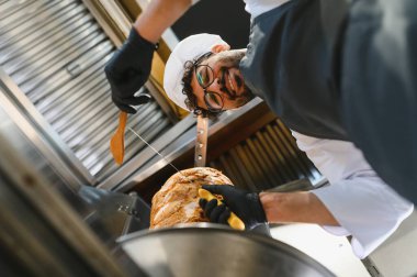 Profesyonel şef döner tükürükten shawarma eti doğruyor, bir yemek kamyonunda lezzetli bir sokak yemeği hazırlıyor.