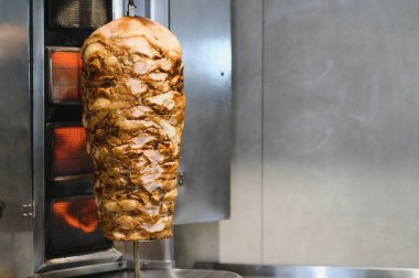 Lezzetli shawarma eti tükürüğün üzerinde dönüyor, profesyonel bir restoranda yavaşça ve eşit derecede pişiriliyor.