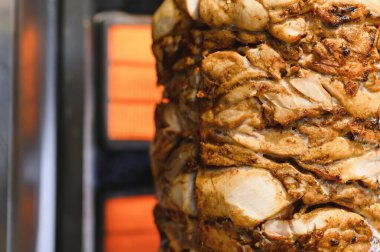 Lezzetli shawarma eti dikey bir tükürükte dönüyor, yavaşça pişiriyor ve havayı karşı konulmaz, ağız sulandıran bir aromayla dolduruyor.