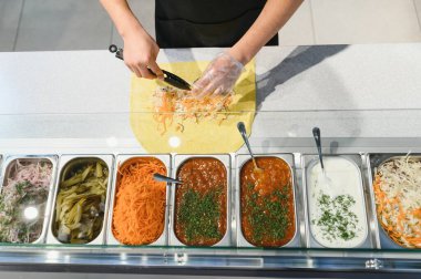 Pide ekmeğine havuç ve lahana ekleyin. Sos, salatalık turşusu ve soğan gibi çeşitli malzemelerle birlikte.