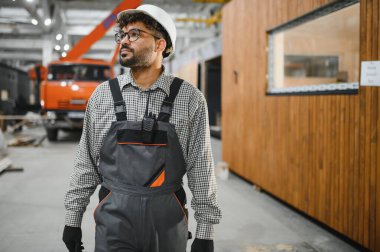 Arap inşaat işçisi büyük inşaat atölyesindeki prefabrik modüler evi geziyor ve inceliyor