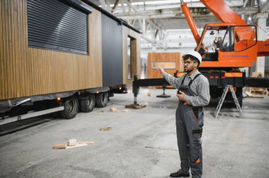 Arap mühendis, prefabrik modüler ev üretim tesislerindeki operasyonları koordine ederek, sorunsuz bir iş akışı ve kalite kontrolü sağlıyor.