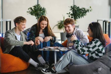 Dört neşeli meslektaşımız oyun molasından keyif alıyor, takım çalışmasını ve arkadaşlığı canlı bir ofis ortamında teşvik ediyorlar.