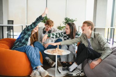 Dört neşeli genç yetişkin, boş zamanlarının tadını çıkarıyorlar. Strateji oyunu oynuyorlar, birlikte gülüyorlar ve eğleniyorlar.