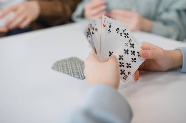 Evde arkadaşça bir kart oyunu sırasında el ele tutuşup, birlikte zaman geçirmenin tadını çıkarıyoruz.