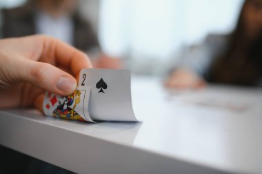 Arkadaşça bir kart oyunu sırasında maça ikisini ortaya çıkarmak, beklenti ve heyecan anı yaratır.