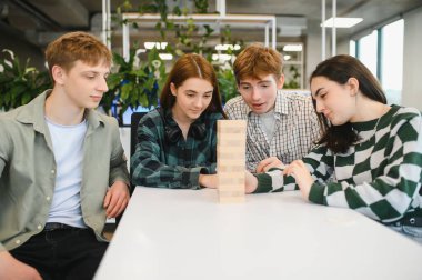 Dört genç meslektaşı oyun molasından zevk alıyor. Büyüleyici bir blok istifleme oyununda hamlelerini dikkatlice planlıyorlar.