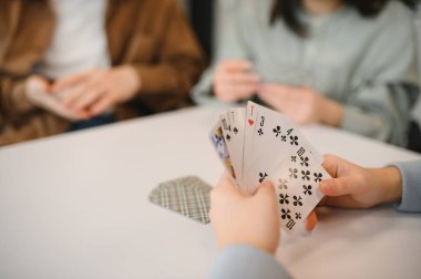 Arkadaşlar bir masanın etrafında toplandılar, oyun oynadılar ve boş zamanlarında kahkahalarla eğlendiler, rahat bir yuva ortamında neşeli anlar yarattılar.