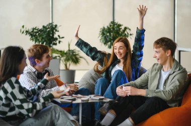 Dört neşeli genç yetişkin birlikte gülüyor ve oyun oynuyorlar, eğlenceli ve arkadaşça yarışmalarla dolu eğlenceli anlar yaratıyorlar.