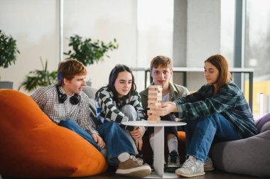 Dört meslektaş mola veriyor, birlikte büyüleyici bir masa oyunu oynuyorlar, rahat bir ofis ortamında takım çalışmasını ve arkadaşlığı teşvik ediyorlar.