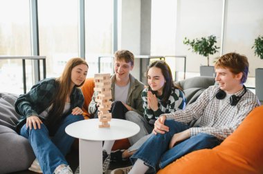 Dört genç arkadaş armut koltukta oturup büyüleyici bir masa oyunu oynuyor ve birlikte vakit geçiriyorlar.