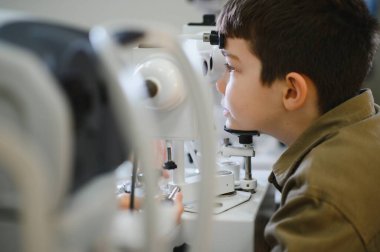 Göz muayenesi sırasında göz muayenesi sırasında göz muayenesi ve göz sağlığı değerlendirmelerine odaklanan bir çocuk