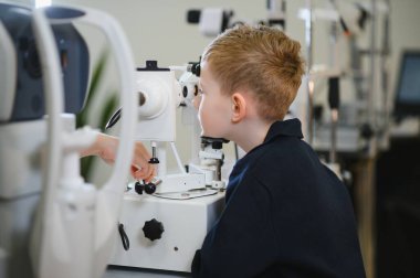 Klinikte özel ekipman kullanan çocuk hastaların görme duyusunu inceleyen oftalmolog, görme tedavisi sunuyor.