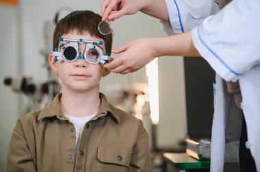 Tıbbi klinikte yapılan bir görüş testi sırasında, göz doktoru, bir çocuğun duruşma çerçevesindeki görüşünü inceliyor.