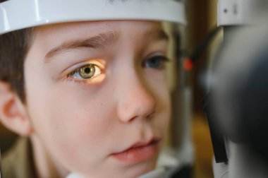 Bir klinikte ileri düzey ekipmanlarla çocuğun görme yetisini inceleyen oftalmolog, görme sağlığı için teşhis ve tedaviye odaklanıyor