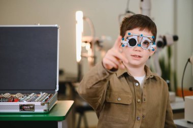 Göz doktorunun klinikte parmağıyla işaret ettiği bir çocuk tarafından deneme aşamasında.