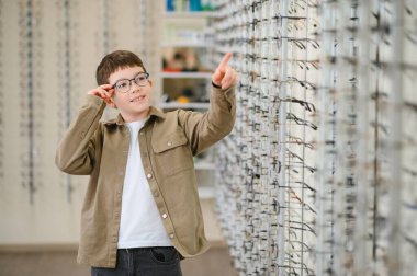 Gözlük deneyen, optik mağazasında çerçeve seçen, görüş kontrolü ve düzeltme, göz hekimi kliniği, sağlık sigortası konsepti
