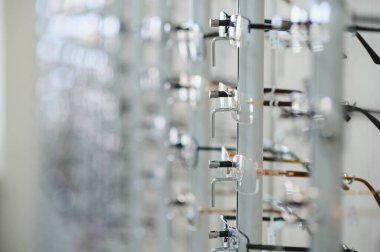 Görme düzeltmesi isteyen müşteriler için optometristin ofisindeki vitrin tezgahında çeşitli gözlükler düzenli olarak düzenlenir