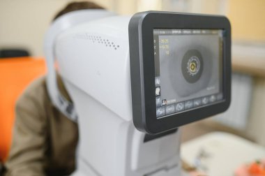 Optalmoloji kliniğinde göz kontrolü sırasında göz ölçülerini gösteren modern otomatik fraktör.