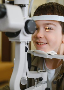 Göz muayenesinden geçen genç bir hasta, klinikteki göz doktoru tarafından biyomikroskop ile inceleniyor.