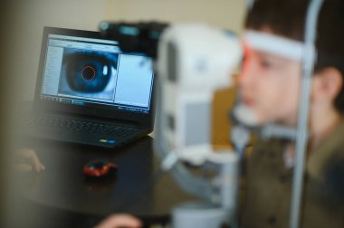 Göz doktorunun yürüttüğü özel ekipmanlarla görme kontrolünden geçen çocuk, çocuklarda göz bakımının önemini vurguluyor.