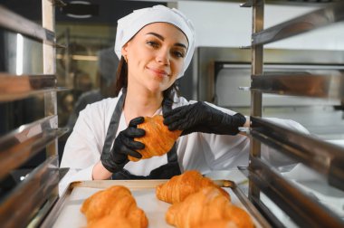 Profesyonel fırıncı gururla sunar mükemmel bir altın kruvasan, zanaatkar pişirmenin kalitesini ve tutkusunu sergiliyor