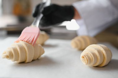 Pişirmeden önce yumurta yıkama ile kruvasan pişirmek, altın-kahverengi bir kabuk ve lezzetli bir aroma sağlar.