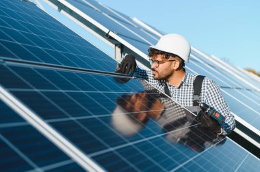 Büyük bir güneş enerjisi santralinde fotovoltaik panel kurulumu üzerinde çalışan Ortadoğu mühendisi.