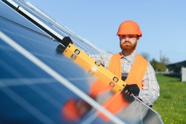 Ruh seviyesine sahip mühendis güneş enerjisi santraline güneş panelleri kuruyor, yenilenebilir enerji ve sürdürülebilirliğe katkıda bulunuyor