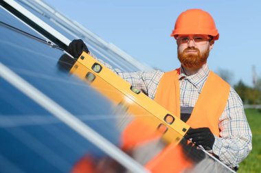 Güneş paneli teknisyeni kurulum sırasında hassas hizalama ve optimal enerji üretimini sağlamak için ruh seviyesini kullanır