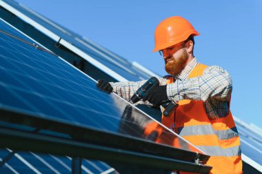 İşçi güneş panelleri kurarak yenilenebilir enerji çözümlerini destekliyor. Projede sürdürülebilir teknoloji ve çevresel koruma üzerinde duruluyor