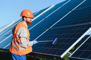 Güvenlik donanımı giyen teknisyenler güneş panellerini ustalıkla kuruyor, sürdürülebilir enerji çözümleri ve çevresel sorumlulukları teşvik ediyor