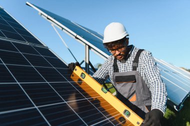 Mühendis, sürdürülebilir enerji üretimine katkıda bulunarak, güneş panellerinin geniş ölçekli bir güneş çiftliğine yerleştirilmesini sağlayan bir seviye aracı kullanıyor.