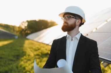 Güneş paneli kurulum projesini gün batımında inceleyen, sürdürülebilir enerji geleceği planlayan, planlı planlı planlı ve sağlam planlı yatırımcı