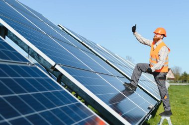 Erkek işçi güneş panelleri kuruyor, yeşil enerji çözümlerini destekliyor. Yenilenebilir enerji kurulumunda sürdürülebilir uygulamaların vurgulanması